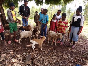 children and staff at the Jerusha Mwiraria Hope Children's Home with goats
